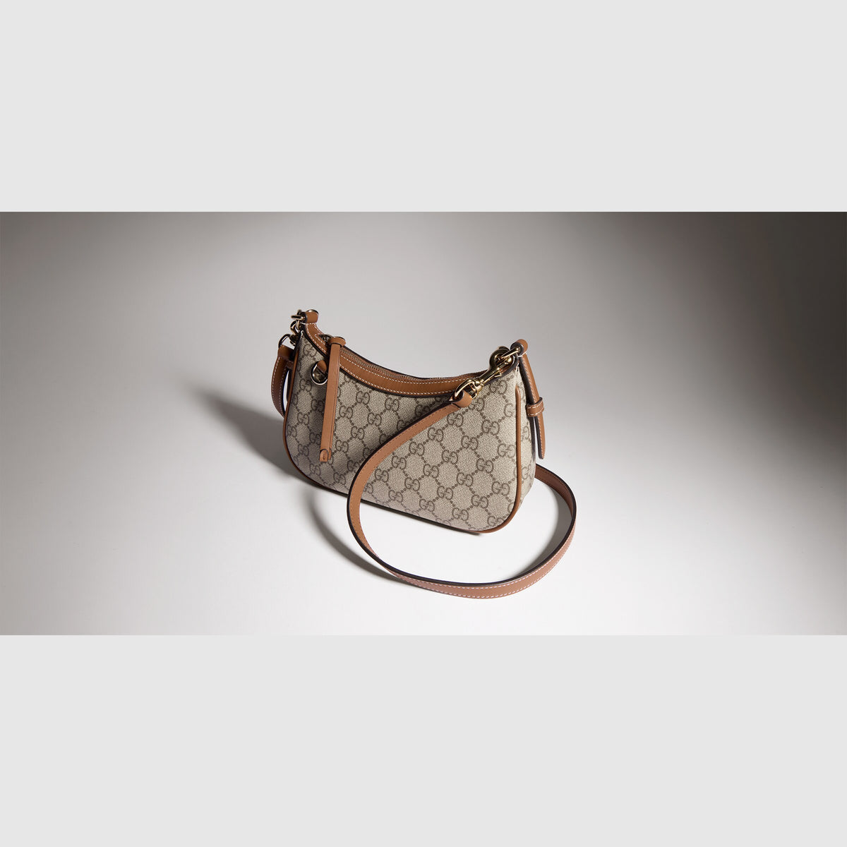 حقيبة كتف GG Emblem صغيرة من Gucci، قماش GG بيج وبني