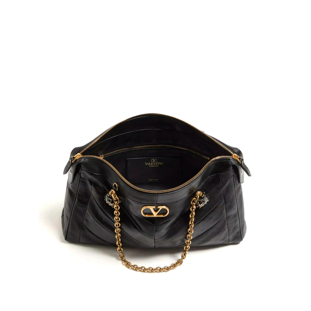 Valentino Garavani VLogo Signature shoulder bag in black — side profile | La Parisienne Qatar